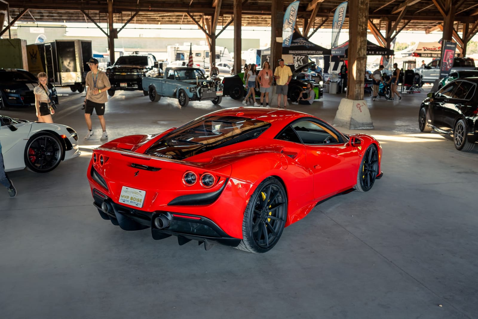 Red Ferrari under a car-show pavilion