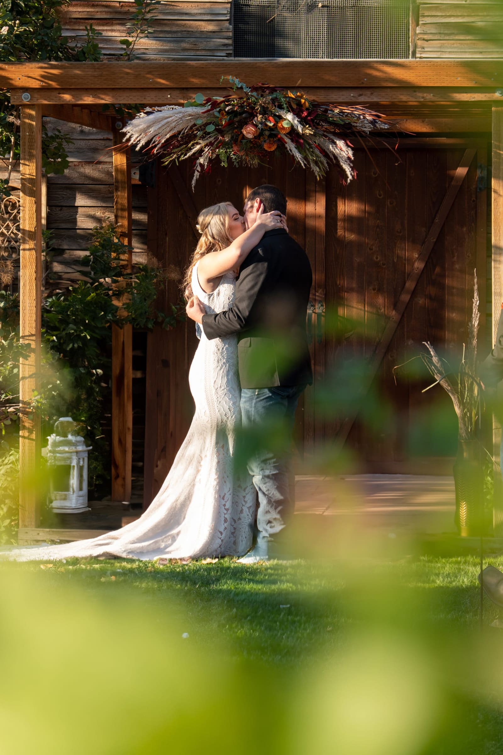 Bride and groom kissing under a wooden altar